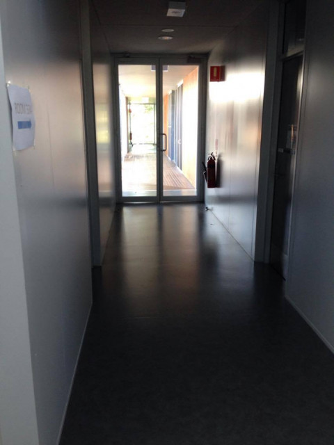 down the corridor before the glass doors