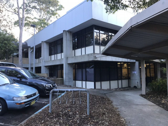 Walkway to office on the right, building entrance on the left